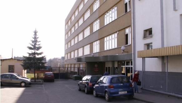 Kilkupiętrowy budynek Trzeciego Urzędu Skarbowego w Bydgoszczy. Pod urzędem stoi kilka aut osobowych.