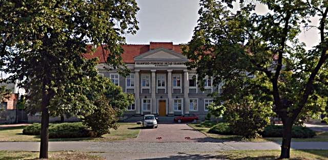 Budynek Kujawsko-Pomorskiego Urzędu Skarbowego w Bydgoszczy. Przed budynkiem klomby i drzewa.