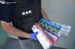 Funkcjonariusz KAS trzyma pudełka z papierosami