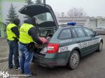 Funkcjonariusze wyciągają nielegalną odzież z bagażnika