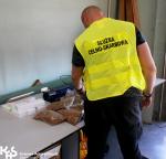 Na zdjęciu funkcjonariusz Krajowej Administracji Skarbowej prezentuje zatrzymane nielegalne wyroby tytoniowe.