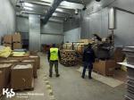 Funkcjonariusz SCS oraz SG w hali do produkcji nielegalnych papierosów