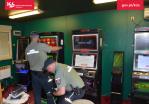 dwaj funkcjonariusze SCS na tle automatów do gier