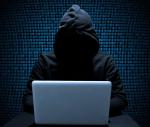Grafika postura człowieka z niewidoczną twarzą, siedzi przed laptopem leżącym na biurku. W tle niebieskie cyfry wyświetlone na całym ekranie.