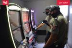 Dwaj funkcjonariusze SCS stoją przed automatami do gier