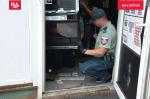 Funkcjonariusz SCS wyjmuje banknoty z automatu do gier