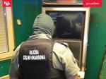 Funkcjonariusz SCS stoi przed automatem do gier