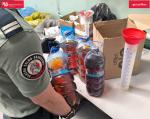 4 duże plastikowe pojemniki z brunatną cieczą