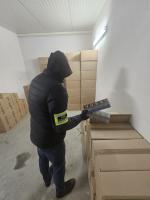 Funkcjonariusz prezentuje znalezione papierosy.