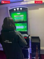 Pomieszczenie w którym stoi automat do nielegalnych gier hazardowych i funkcjonariuszka SCS przed automatem. 