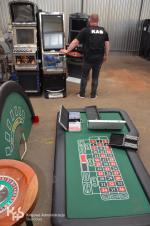 Funkcjonariusz KAS ogląda nielegalne automaty do gry