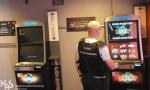 Funkcjonariusz KAS stojący przy dwóch automatach do gier hazardowych